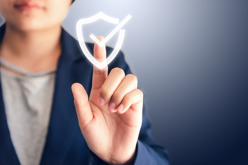 En kvinna pekar på en illusterad diplomsymbol med checkbock som ska illustrera avklarat prov för en personcertifiering. . 