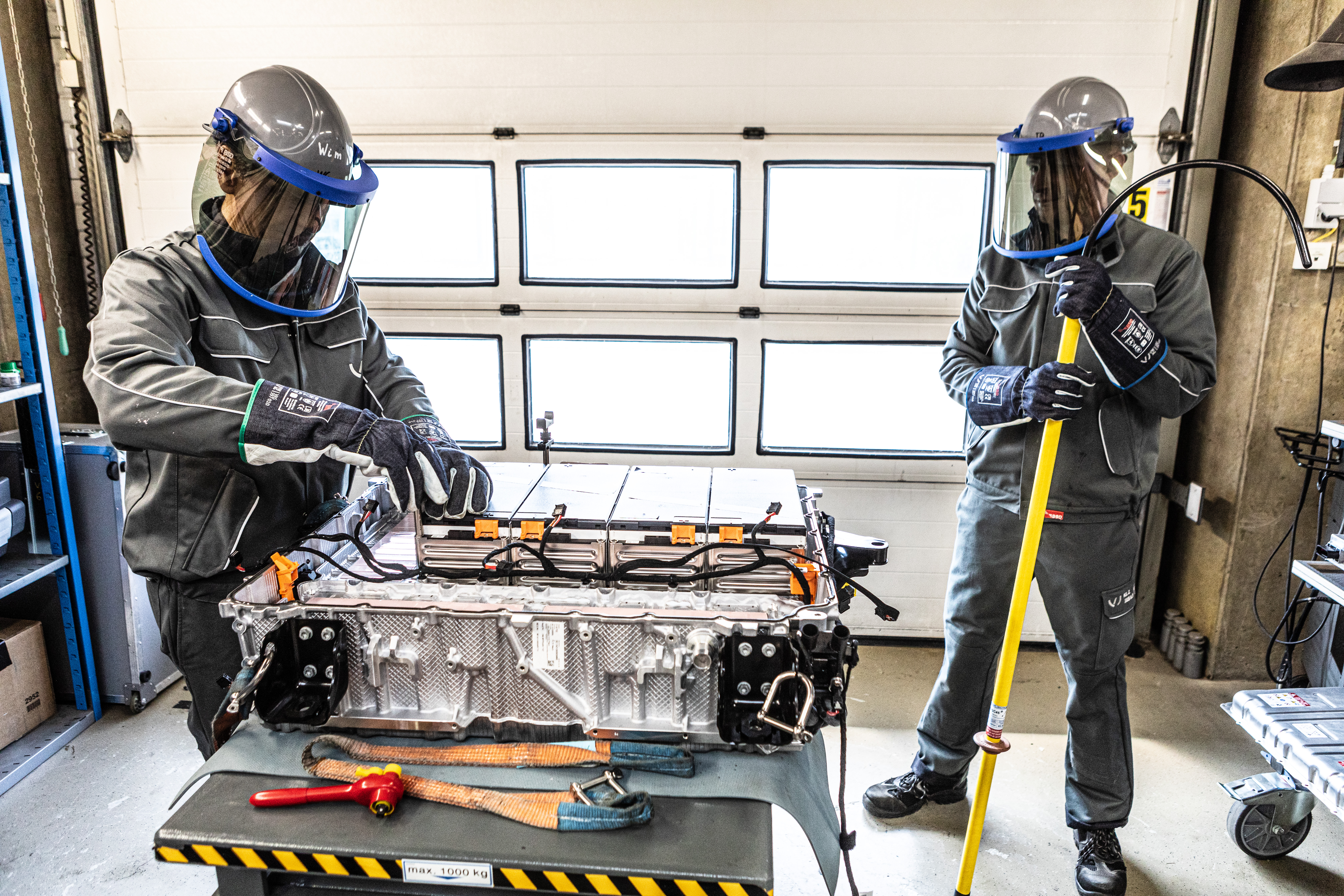 Two inspectors review a car battery