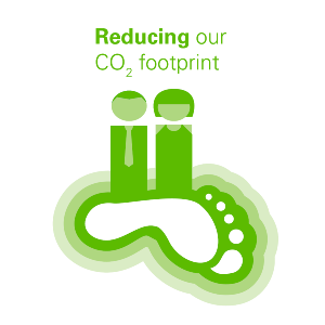 Graphic depicting two figures standing on a large footprint, with the text "Reducing our CO₂ footprint" above in green.