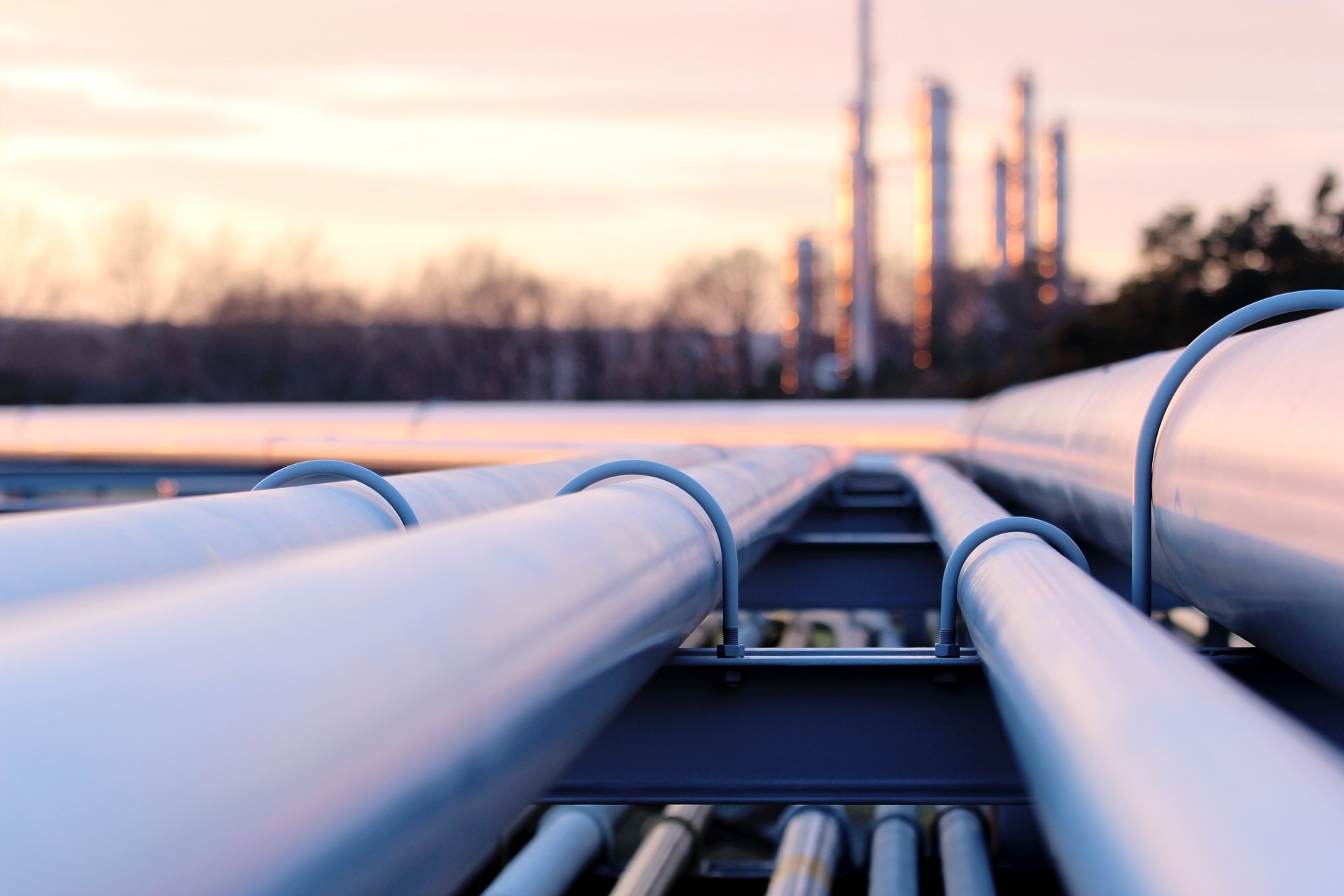 Industrial pipeline network and smokestacks in the background